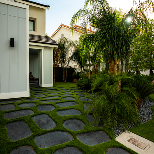 artificial grass surrounding puka lava in a front yard of a house