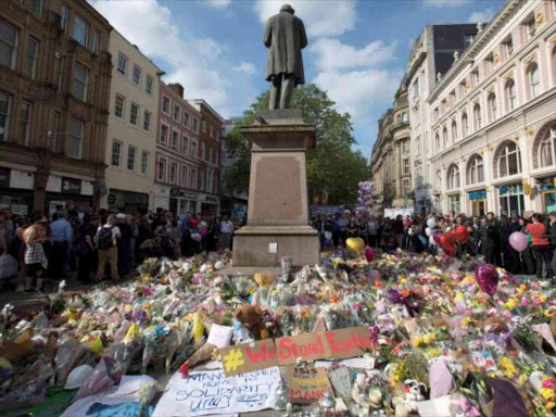 Messages and floral tributes left for the victims of the attack on Manchester Arena lie around the statue in St Ann's Square in central Manchester, May 24, 2017. REUTERS