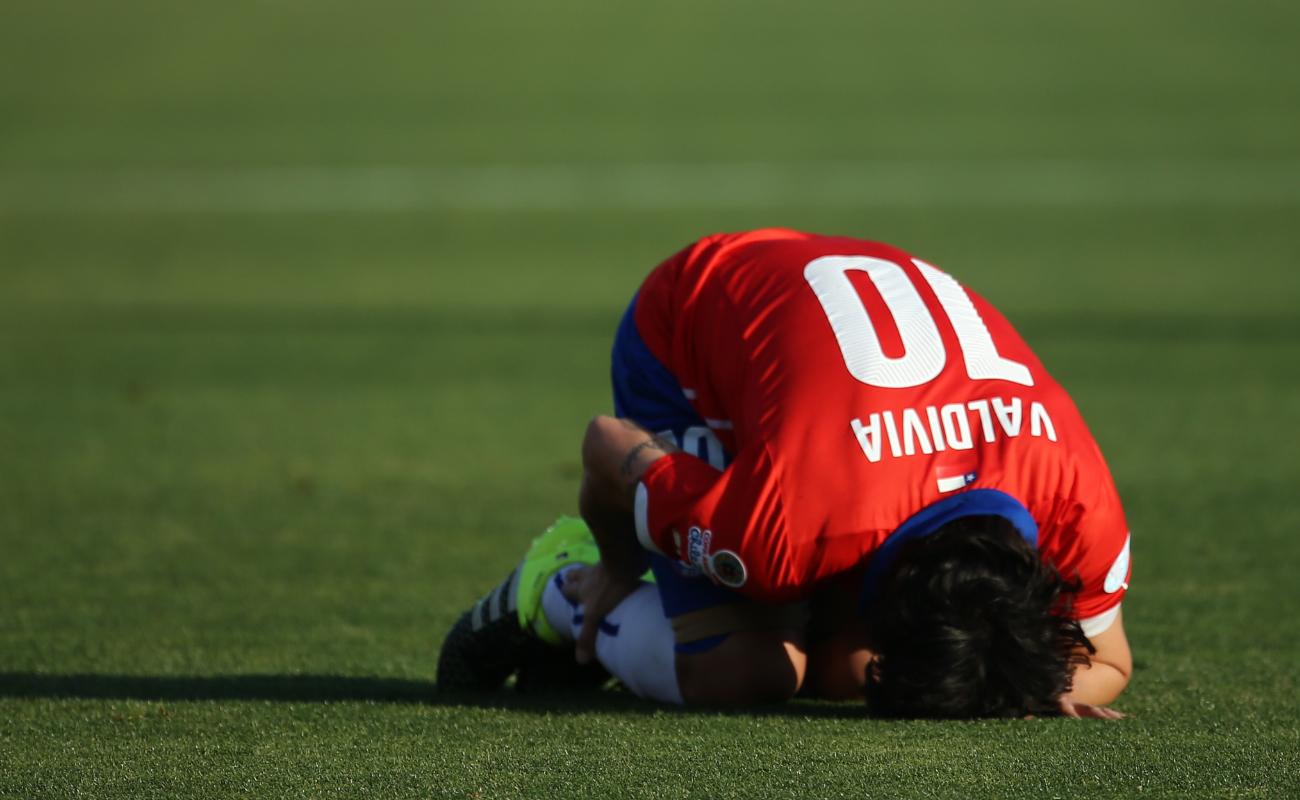 Soccer player injured on a green turf.