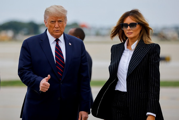 US President Donald Trump walks with first lady Melania Trump.