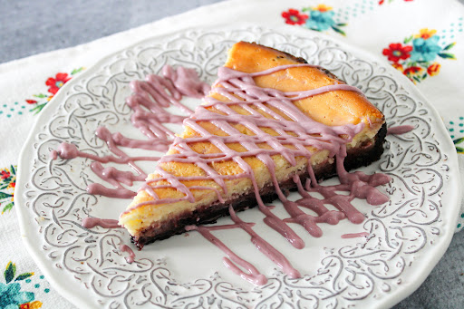 A slice of Oreo Blackberry Cheesecake on a plate.