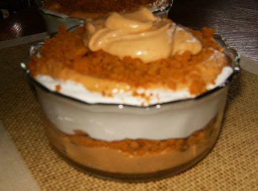 Pumpkin Cheesecake Pudding shown with crushed ginger snap cookies.