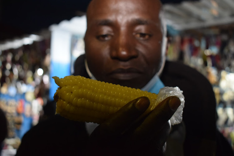 Man enjoys a piece of boiled maize.