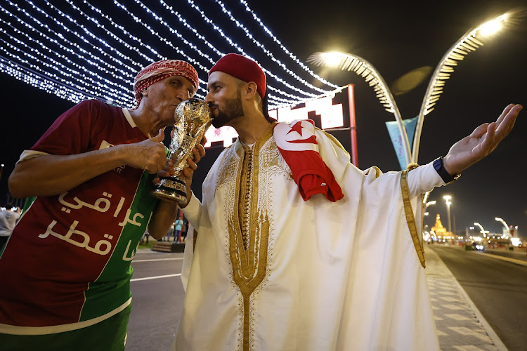 Supporters kiss a replica of the World Cup trophy ahead of the 2022 Fifia World Cup in Doha, Qatar, November 16 2022. Picture: BUDA MENDES/GETTY IMAGES