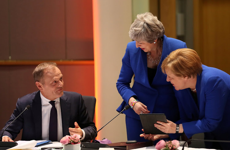 Britain's Prime Minister Theresa May and Germany's Chancellor Angela Merkel look at a tablet next to European Council President Donald Tusk, ahead of a European Council meeting on Brexit at the Europa Building at the European Parliament in Brussels, Belgium April 10, 2019.