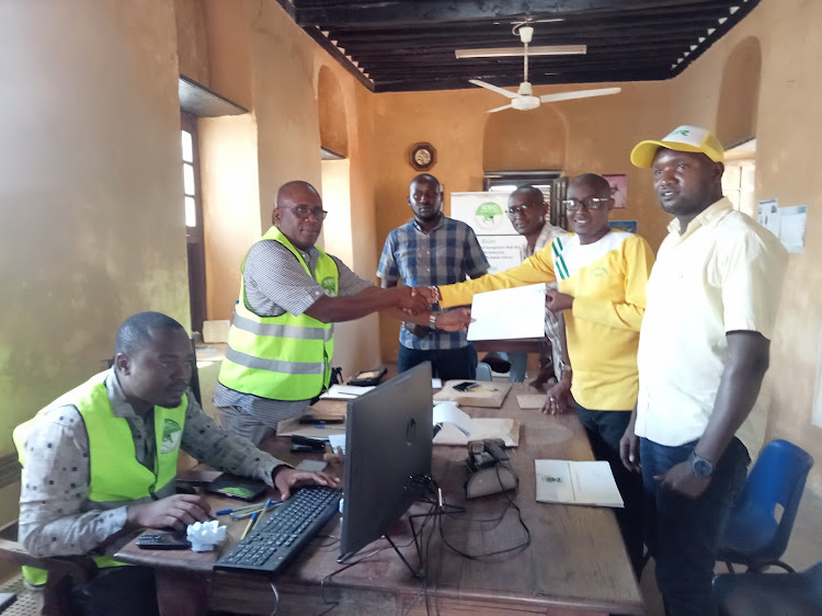 Francis Mugo of UDA receives his clearance certificate from Lamu county IEBC coordinator Maro Ade.