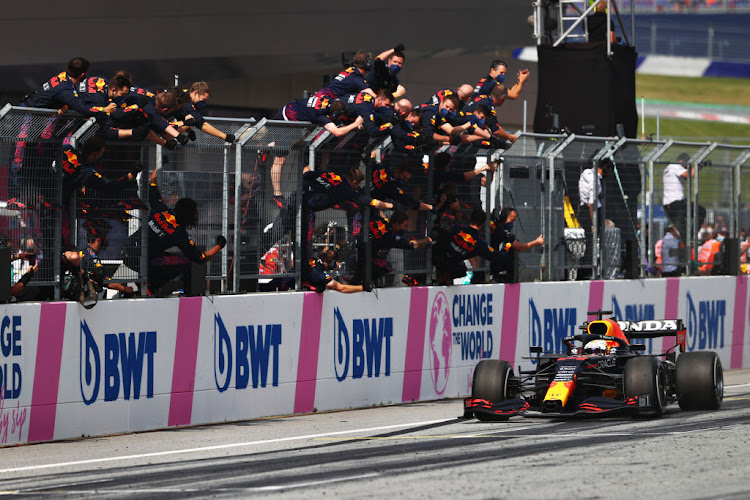 Race winner Max Verstappen passes his team celebrating on the pitwall during the F1 Grand Prix of Austria at Red Bull Ring on July 04, 2021 in Spielberg, Austria.