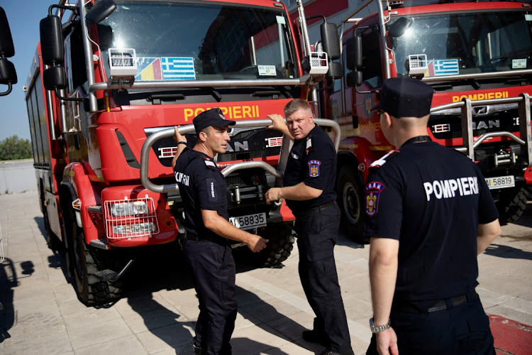 Romanian firefighters, who will reinforce their Greek colleagues during the summer season to tackle wildfires in the country, stand next to their vehicles in Athens, Greece, on July 2 2022.