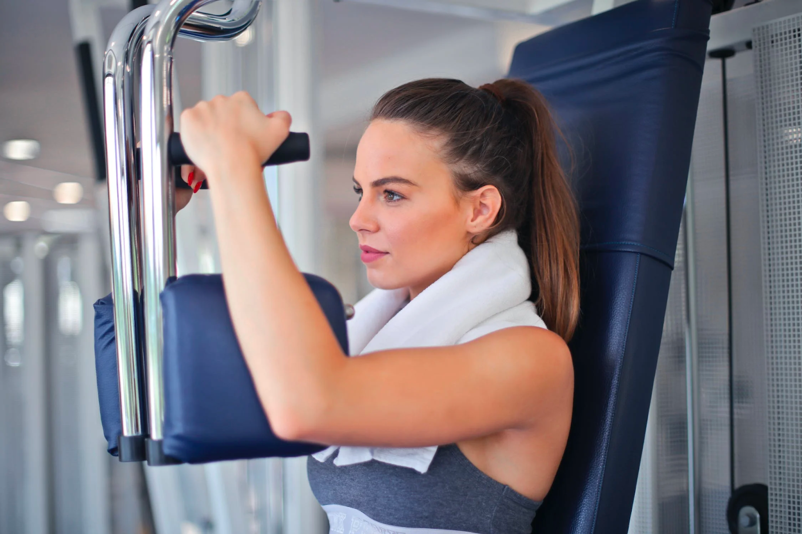 Woman uses weight machine at gym to help with weight loss.