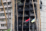 Ukrainian national flag and red-and-black nationalist flag flutter outside a partially destroyed civilian building in Irpin, Ukraine June 16, 2022.