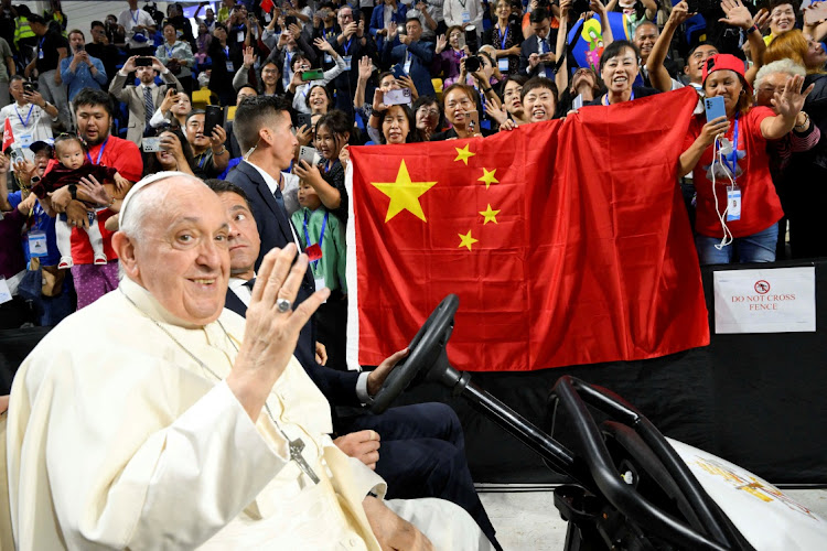 People hold a Chinese flag as Pope Francis waves at the Steppe Arena in Ulaanbaatar, Mongolia, September 3 2023. Picture: VATICAN MEDIA/HANDOUT/REUTERS