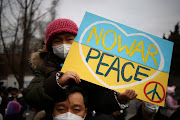 A father and his daughter attend a protest against the massive military operation by Russia against Ukraine, near the Russian embassy in Seoul, South Korea, February 28, 2022.