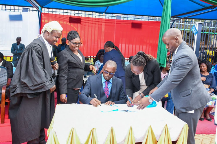 Bungoma County Attorney Cyril Wayong'o directs newly appointed CECM's to sign commitment book after taking oaths on Friday.