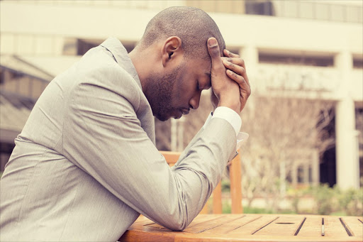 stressed businessman sitting outside corporate office - Stock