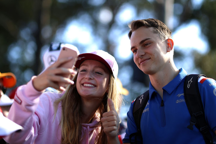 Australia's Oscar Piastri poses for a selfie with a fan.