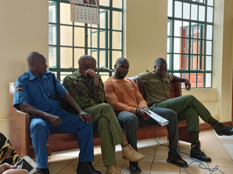 Police officers and Collins Okundi, suspect in the murder of Ida Odinga's bodyguard at the Kisumu High Court on Monday 17th 2022.