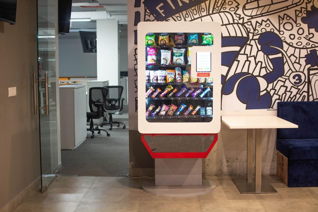 A vending machine standing in the breakroom of an office