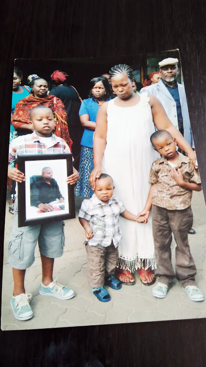 Scholastica Mbala with her children during the burial of her husband/Courtesy