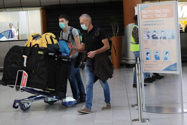 Passengers arrive at Cape Town International Airport on March 12 2020 wearing face masks to prevent being infected with the coronavirus.​