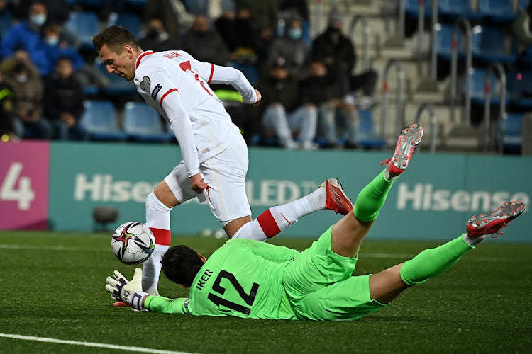 Polish forward Arkadiusz Milik (L) challenges Andorra’s goalkeeper Iker Alvarez during a Fifa World Cup Qatar 2022 qualifier on November 12