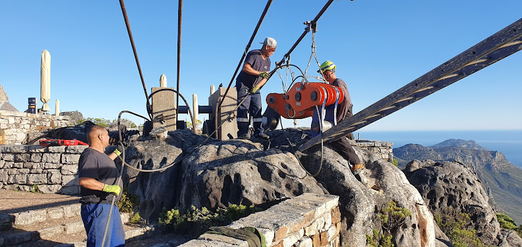 Technicians on top of Table Mountain get to grips with one of the cableway's track ropes.