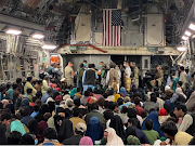 A newborn baby is looked after prior taking off with other Afghan evacuees on a C-17 Globemaster III at a Middle East staging area on August 23 2021. 