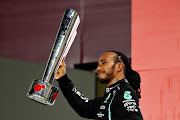 Race winner Lewis Hamilton celebrates on the podium during the F1 Grand Prix of Qatar at Losail International Circuit on November 21, 2021 in Doha, Qatar.