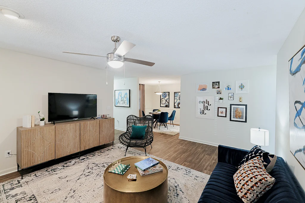 Furnished living room and dining room areas with wood-inspired flooring, light walls, and a ceiling fan