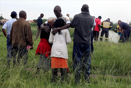 January 2017. Family members, relatives and friends gather near a stream as the search and rescue team recovers the body of Ndivho Malatsi , who was swept away on Monday after heavy rains. The Grade 7 pupil was on her way home from school in Tembisa on the East Rand. Pic: Sandile Ndlovu. © Sowetan