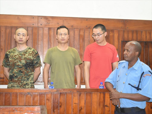 Employees of China Roads and Bridge Corporation at the Standard Gauge Railway Li Gen (security manager), Li Xiaowu (security manager) and Sun Xin (translator) in Mombasa Court for bribery charges on Monday. /ANDREW KASUKU