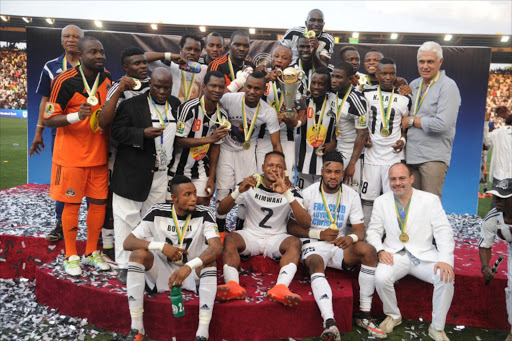 TP Mazembe players celebrate with the trophy after winning the second leg of the CAF Confederation Cup final against the MO Bejaja in Lubumbashi on November 6, 2016.