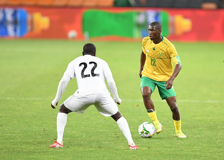 Bafana Bafana's Bongokuhle Hlongwane is challenged by Gilroy Chimwemwe of Zimbabwe in the 2022 Fifa World Cup qualifier at FNB Stadium in Johannesburg on November 11 2021.