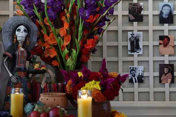 Family photos are seen on the wall of a Día de los Muertos ofrenda display at the White House on November 1 2022 in Washington, DC. The White House partnered with the National Museum of Mexican Art in Chicago for the display to showcase photos of White House staff’s lost loved ones to celebrate their lives and memories.