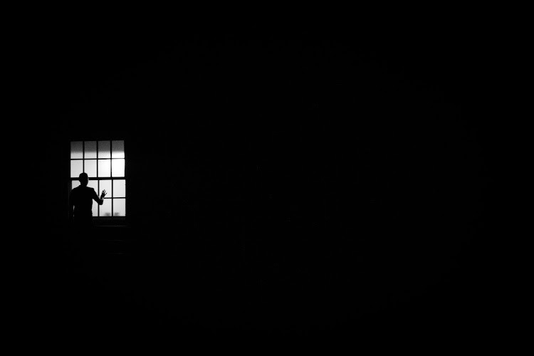 Isolated person looks out the window