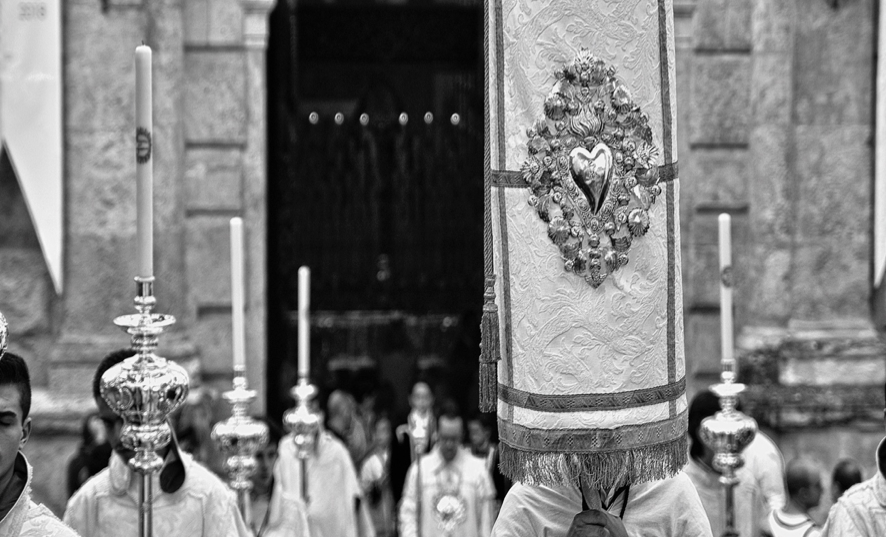 Imagem em preto e branco de uma procisso com menbros da igreja catlica