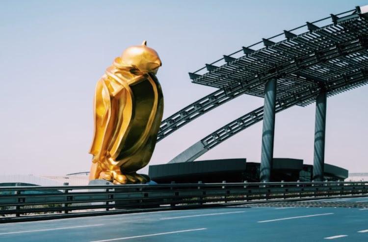 A 12m-tall golden falcon stands sentry at Hamad International Airport.