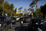 A man holds an Ukrainian flag during an anti-war protest in front of the Russian embassy following Russia's invasion of Ukraine, in Santiago, Chile, March 5, 2022. 