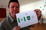 Designer Tonu Kukk holds a paper with a design of Kanepi municipality's flag and coat of arms featuring a cannabis leaf after the municipality council's vote in Polgaste, Estonia May 15, 2018. Kanep is the Estonian word for cannabis.