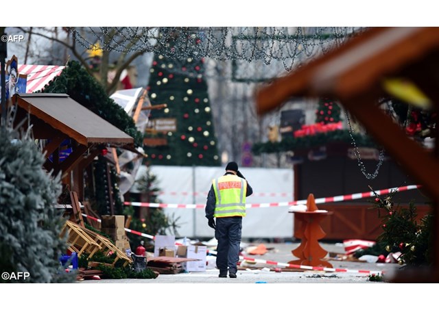 A policeman walks at the Christmas market in Berlin the day after a terror attack   - AFP