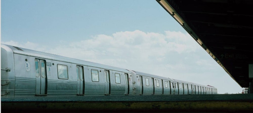 Photograph of a blue and white train in motion inside a train station