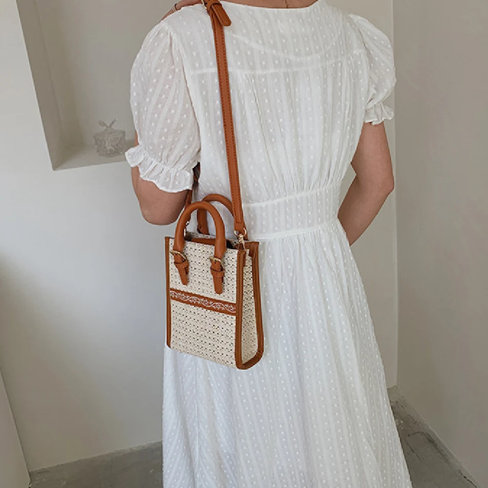 Sac bandoulière ethnique en paille tressée, portable et pratique pour transporter vos essentiels avec élégance et légèreté.