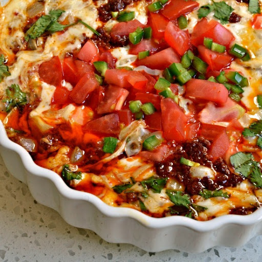 This Mexican dish is layered with melted cheese, chorizo, sauteed onions and topped with diced tomatoes, minced jalapeno and chopped fresh cilantro.  Serve hot with tortillas or tortilla chips.