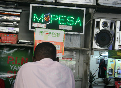 A customer waits to be served at an M-Pesa shop.