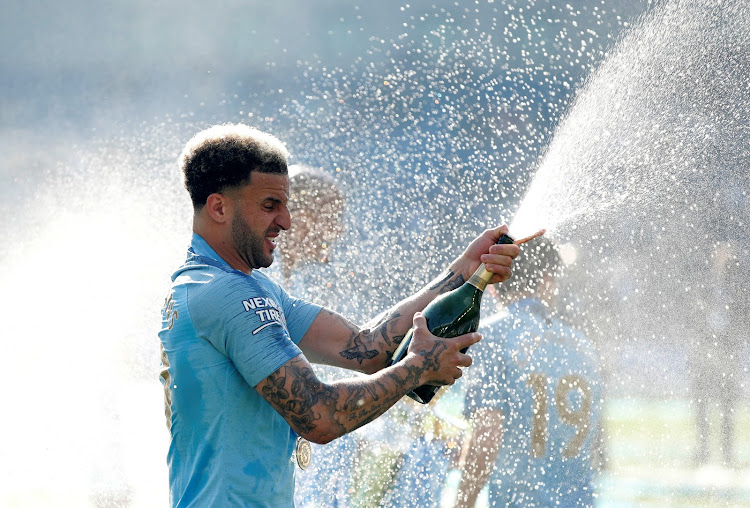 Manchester City's Kyle Walker sprays sparkling wine as he celebrates winning the Premier League