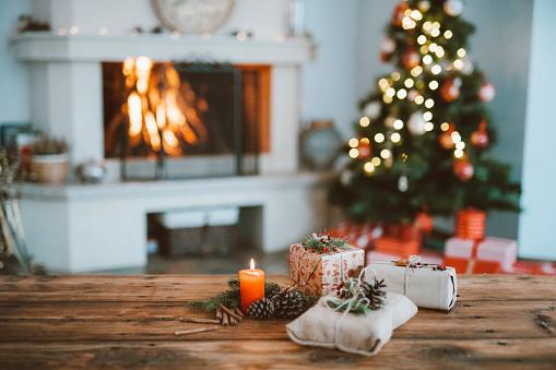 WeServe, holiday decorations on a wooden table with a background of a christmas tree and a working fireplace