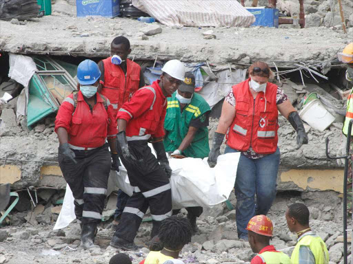 Kenya Red Cross officials carry a body retrieved from the collapsed Huruma building yesterday / MONICAH MWANGI