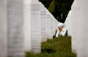 A woman cries at a graveyard, ahead of a mass funeral in Potocari near Srebrenica, Bosnia and Herzegovina July 11, 2020. Bosnia marks the 25th anniversary of the massacre of more than 8,000 Bosnian Muslim men and boys, with many relatives unable to attend due to the coronavirus disease (Covid-19) outbreak. 