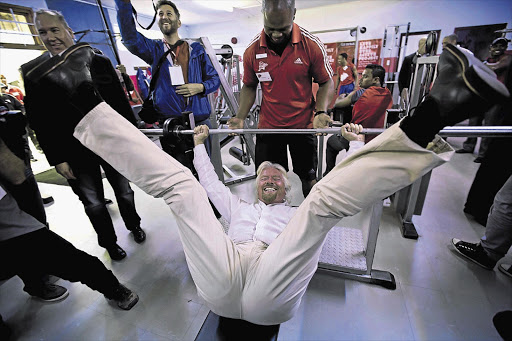 UPLIFTING: British businessman Sir Richard Branson tries out the new gym that his company built at Lavender Hill High School on the Cape Flats