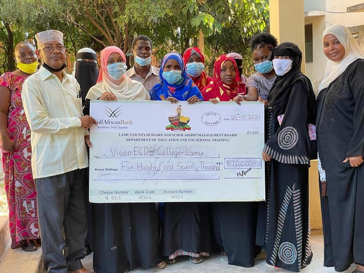 Lamu government officials hand over a dummy cheque to the Vision ECDE College