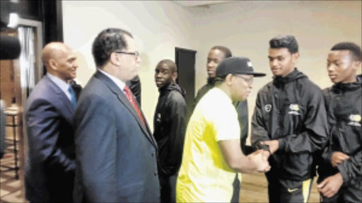 HEROES : Sport Minister Fikile Mbalula, wearing cap, Safa president Danny Jordaan and Safa CEO Dennis Mumble welcome back the under-17 team after beating Egypt to qualify for the 2015 CAF African Championships Photo: Farren Collins